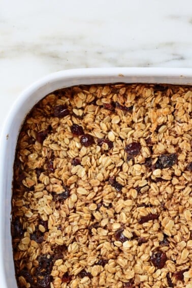 Baked Oatmeal in a white baking dish on a marble surface.