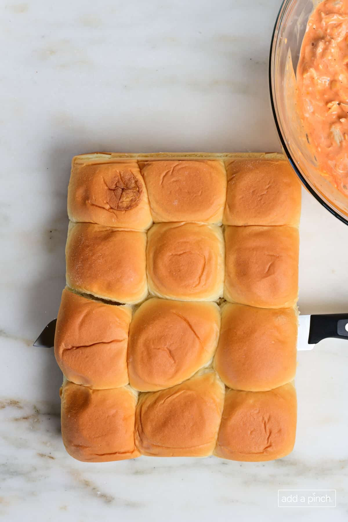 Rolls for the buffalo chicken sliders being sliced in half.