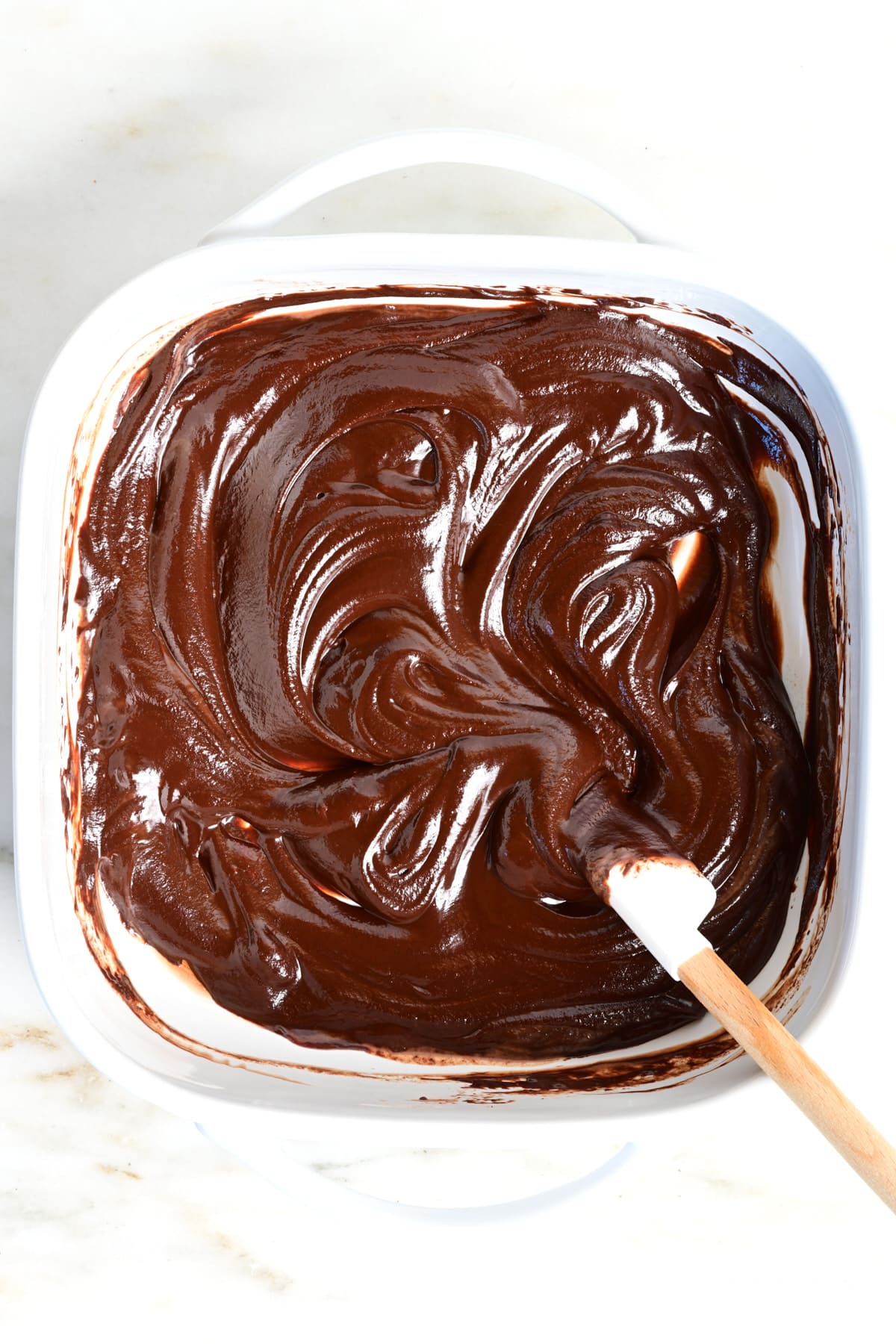 Warm ganache in a white baking dish.