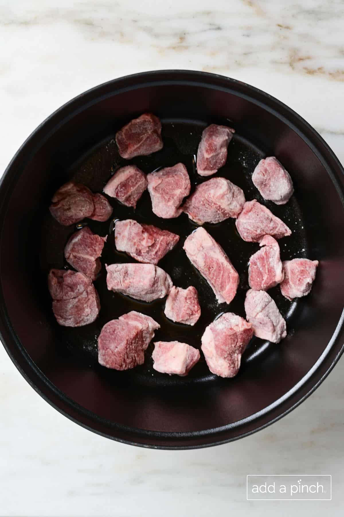 Seasoned lamb cooking in olive oil for Irish Stew.