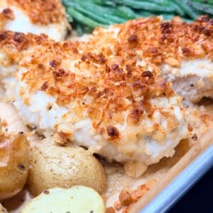 Finished sheet pan chicken dinner showing crispy potatoes and roasted green beans.