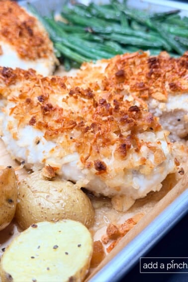 Finished sheet pan chicken dinner showing crispy potatoes and roasted green beans.