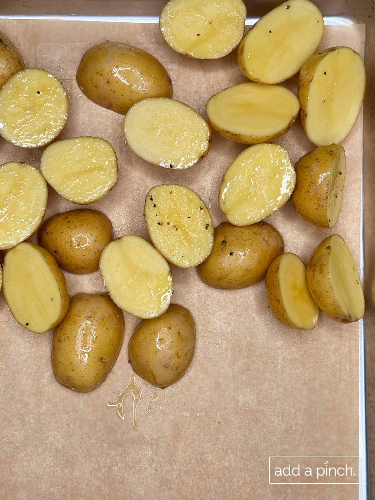 Baby potatoes on a parchment-lined baking sheet ready for baking.