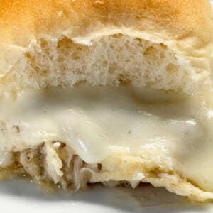 Close up of a Mississippi Chicken Slider with shredded pepperoncini chicken and melted provolone on a soft slider roll.