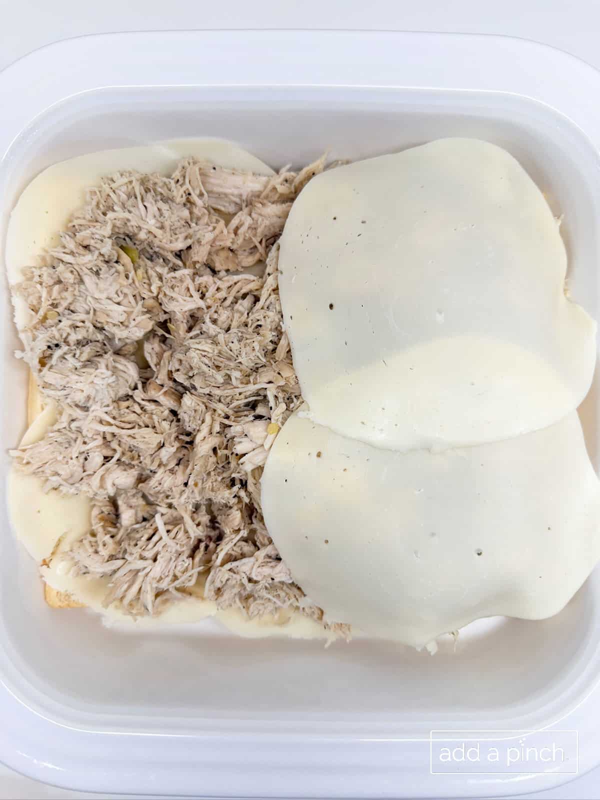 Mississippi chicken sliders assembly with rolls on the bottom, chicken, and then provolone on top.